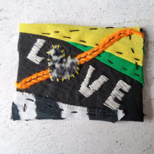 Punk looking ATC. From bottom left to top right corner, it has zebra fabric, black fabric, a piece of bright green and one of bright yellow. LOVE is written in white on the black part, the O is a heart cut from leopard faux fur fabric